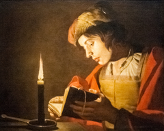 A Young Man Reading at Candlelight