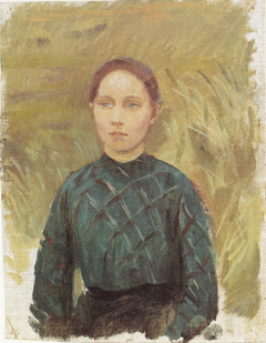 Young woman in a green dress,  sitting in the dunes