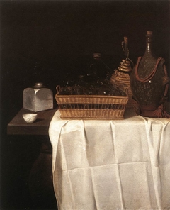 Tisch mit Gläserkorb, Flaschen, Schraubdose und Teeschale