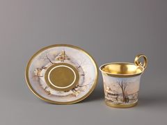 Cup and saucer with painted winter scenes