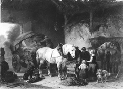 Een vrachtwagen en enige paarden in een stal
