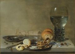 Still life of roemer and a façon de Venise glass, lemon, watch and capers on pewter plates, together with knife, bread and hazelnuts